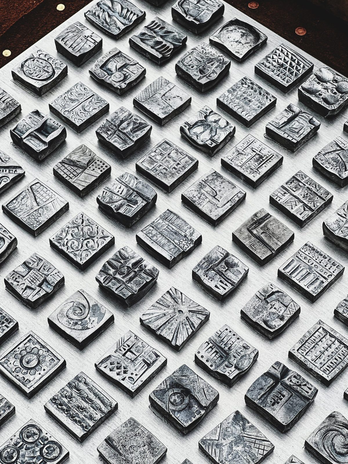 Hashmarks — a grid of small hand-forged iron tiles, each face uniquely patterned.
